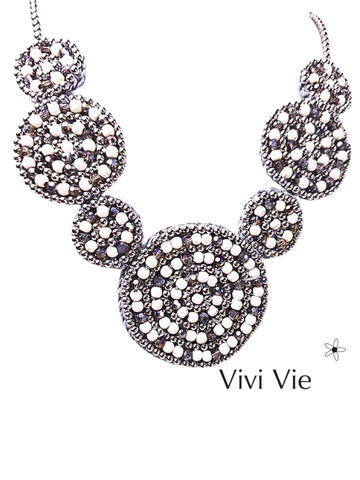Beauiful and bold stament necklace with a neutral  palate and graduating circular  beaded design